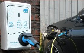 Laadpaal aan de gevel met een elektrische auto aan de lader
